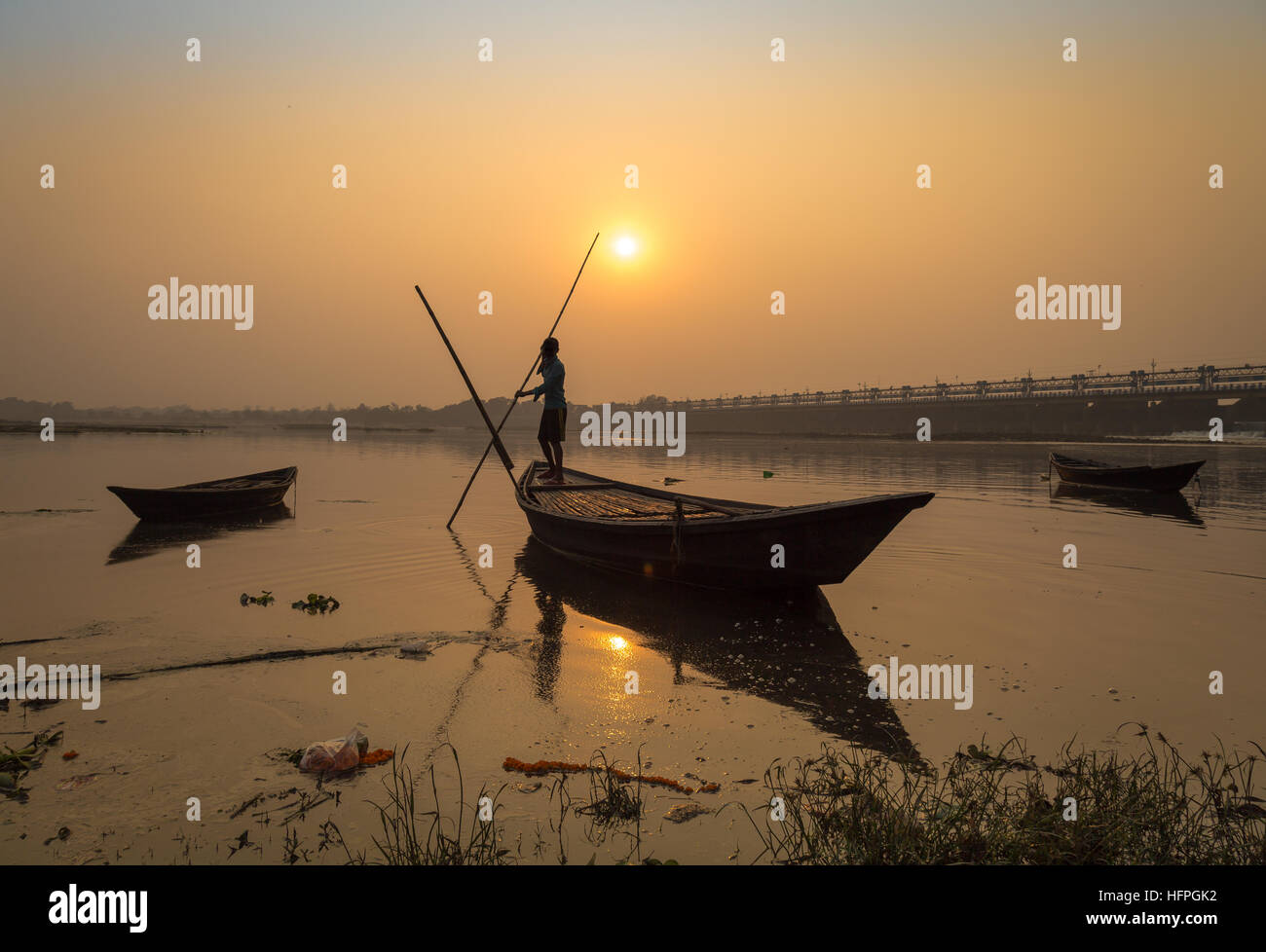 Silhouette wooden boat with oarsman at sunset on river Damodar, Durgapur Barrage, West Bengal, India. Stock Photo