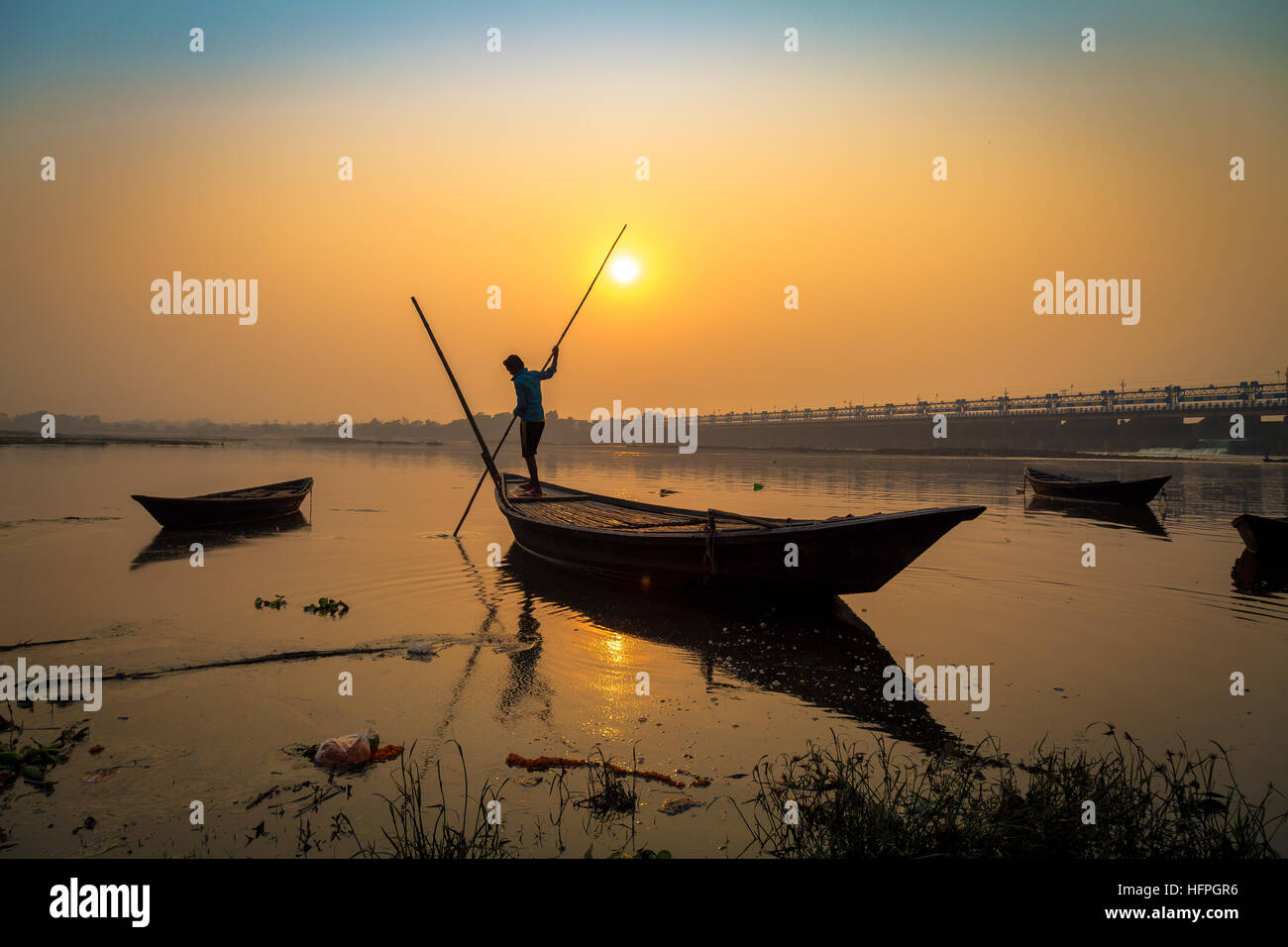 Silhouette boat with oarsman at sunset on river Damodar, Durgapur Barrage, West Bengal, India. Stock Photo