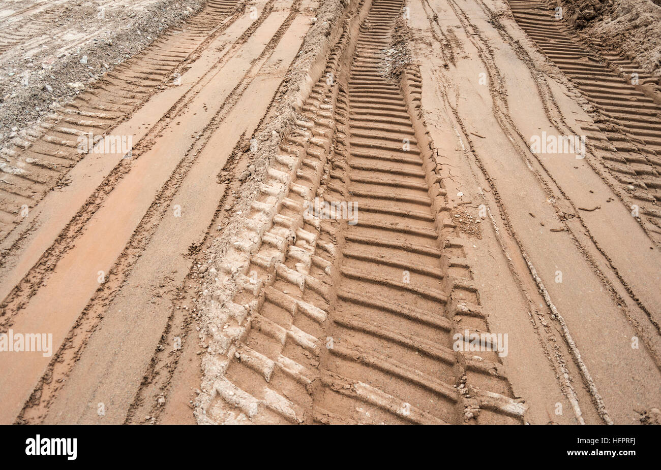 Bulldozer tracks on a surface of brown and gray sand Stock Photo