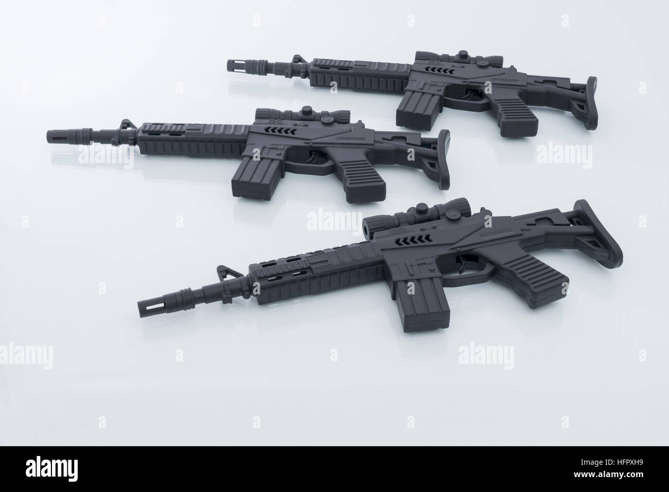 Black toy assault rifles as visual metaphor for concept of gun