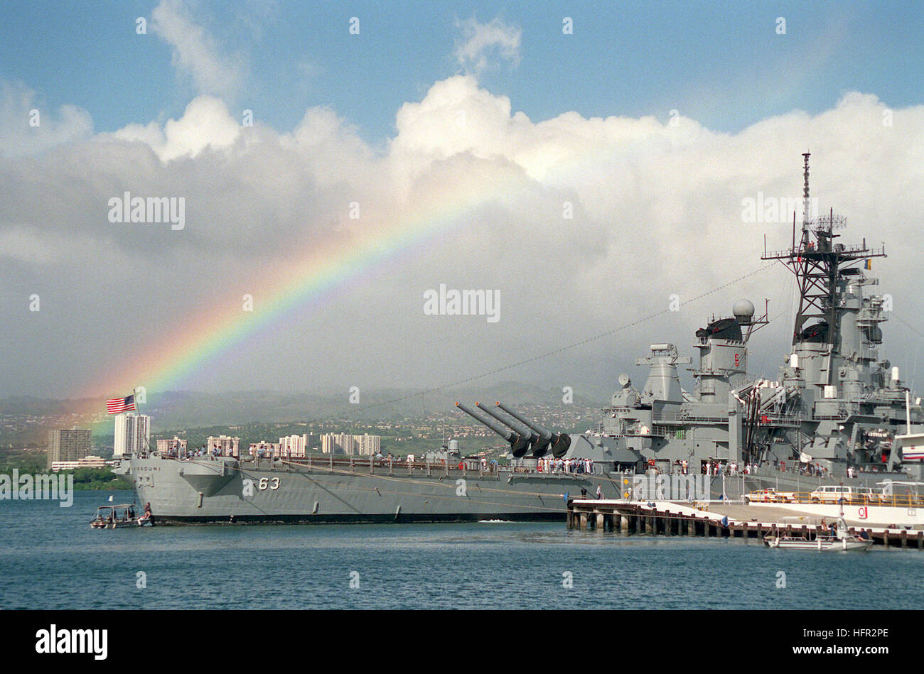 A rainbow highlights the sky in the background as the battleship USS MISSOURI (BB-63) lies tied up at the naval station.  The MISSOURI is in Hawaii to take part in the observance of the 50th anniversary of the Japanese attack on Pearl Harbor. USS Missouri (BB-63) rainbow Stock Photo
