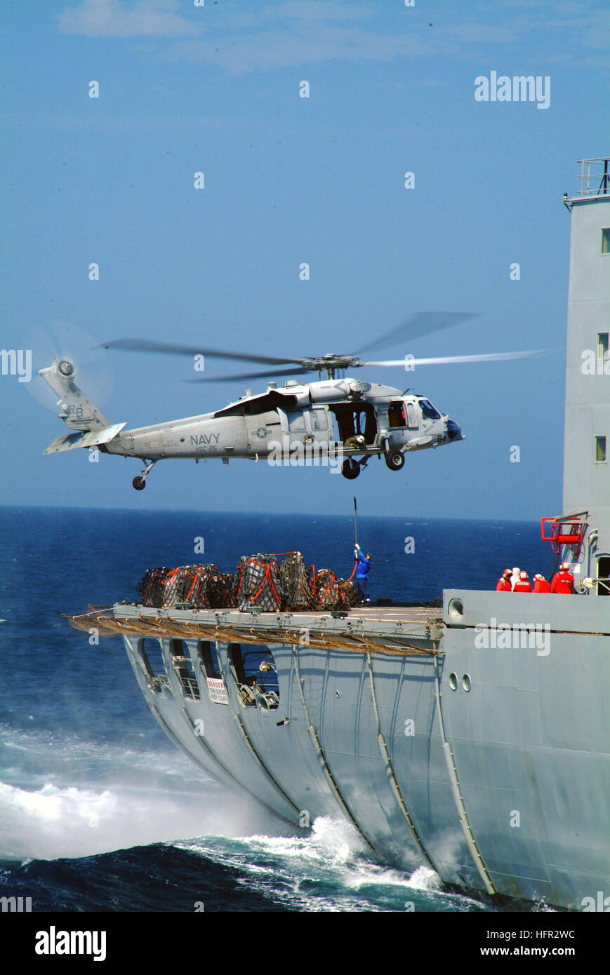 060225-N-4772B-112  Philippine Sea (Feb. 25, 2006) - An HS-60S Seahawk from the Island Knights of Helicopter Sea Combat Squadron 25 (HCS-25) maneuvers over the flight deck of the Military Sealift Command (MSC) fleet replenishment oiler USNS Yukon (T-AO 202), while transferring supplies to the dock landing ship USS Harpers Ferry (LSD 49). Sailors and Marines from the Forward Deployed Amphibious Ready Group (ARG), USS Harpers Ferry (LSD 49) and USS Essex (LHD 2) arrived off the coast of Leyte Feb. 19 to provide humanitarian assistance and disaster relief to victims of the Feb. 17 landslide on th Stock Photo