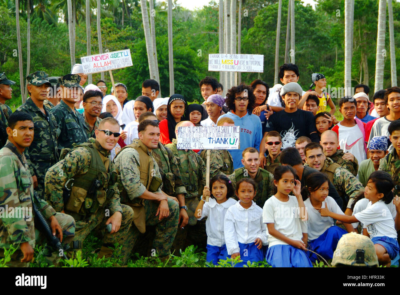 060303-N-4772B-128 Jolo, Philippines (March 3, 2006) - Philippine Marines and villagers from the nearby town of Tiptipon pose with U.S. Marines and Sailors assigned to the 31st Marine Service Support Group (MSSG) before they depart the island for transit back to the amphibious dock landing ship USS Harpers Ferry (LSD 49). The joint efforts of more than 500 AFP and U.S. medical, dental, engineer and protection personnel were able to bring medical and dental support to more than 11,000 Filipino people and 504 animals, along with building four elementary schools. Harpers Ferry and Elements of the Stock Photo