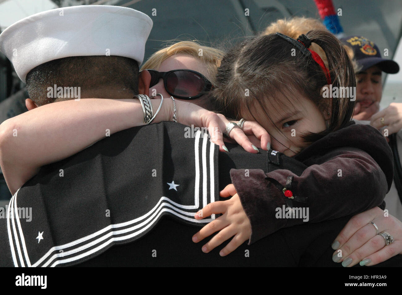 060309-N-9562H-043 Norfolk, Va. (March 9, 2006) - Seaman Paul Martinez hugs his wife and daughter after returning from a six-month deployment aboard the guided missile destroyer USS Donald Cook's (DDG 75). Donald Cook was deployed in support of the in support of the global war on terrorism. U.S. Navy photo by Lithographer's Mate Seaman Recruit Shanika Futrell (RELEASED) US Navy 060309-N-9562H-043 Seaman Paul Martinez hugs his wife and daughter after returning from a six-month deployment aboard the guided missile destroyer USS Donald Cook's (DDG 75) Stock Photo