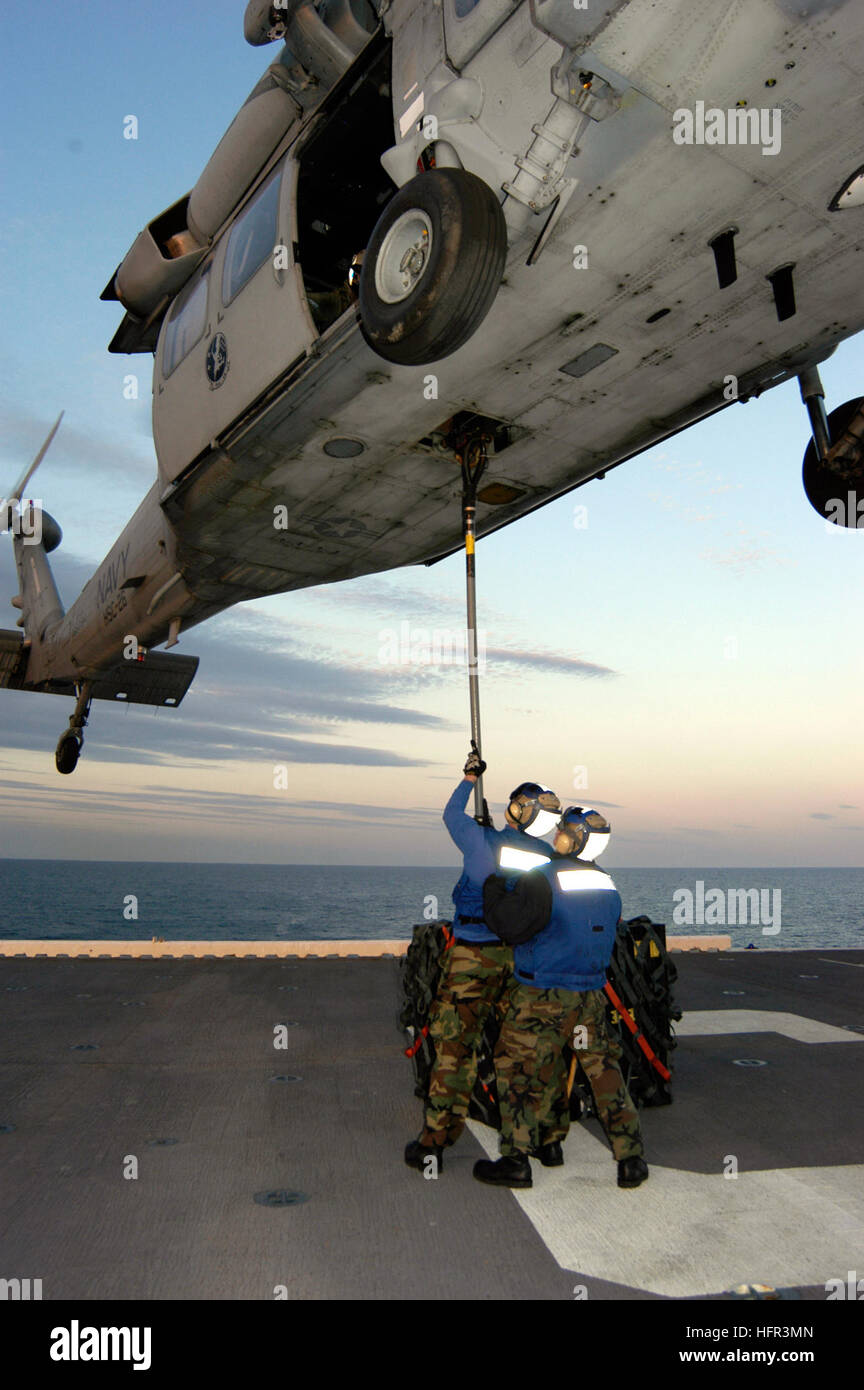 060316-N-6482W-084 Atlantic Ocean (March 16, 2006) - Two aircraft handlers stationed aboard the amphibious assault ship USS Bataan (LHD 5) prepare to complete a vertical replenishment (VERTREP) with a MH-60 Seahawk. Bataan is underway preparing for an upcoming deployment. U.S. Navy photo by Lithographer 3rd Class Justin S. Webster (RELEASED) US Navy 060316-N-6482W-084 Two aircraft handlers stationed aboard the amphibious assault ship USS Bataan (LHD 5) prepare to complete a vertical replenishment (VERTREP) with a MH-60 Seahawk Stock Photo