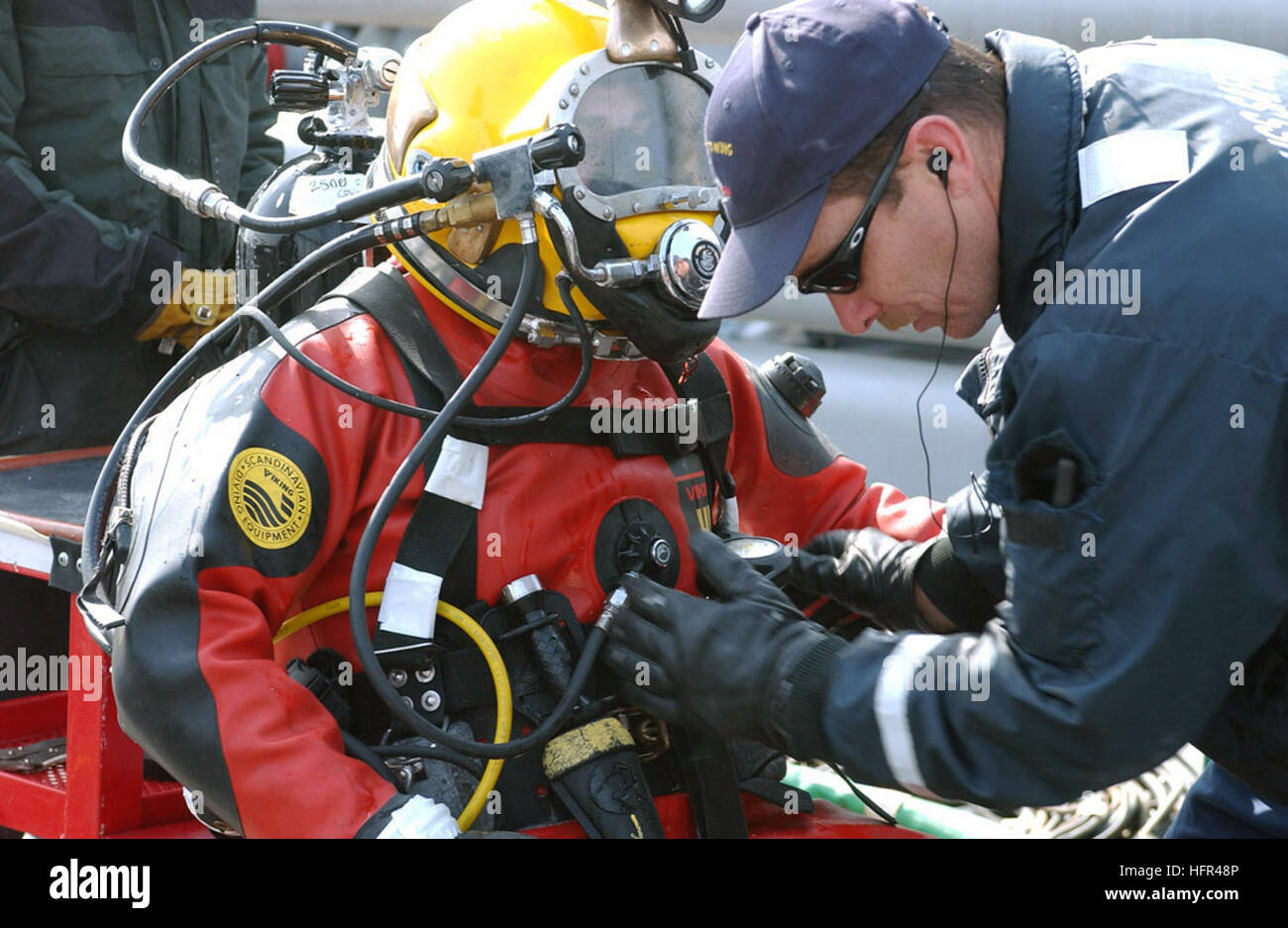 060329-F-3759D-003 Yellow Sea (March 29, 2006) - Chief Hull Technician Cliff Morin assigned to the rescue and salvage ship USS Safeguard (ARS 50) prepares a Safeguard crewmember to dive near the wreckage of a U.S. Air Force F-16C lost at sea on March 14th. Safeguard crews and the Republic of Korea Navy ship ROKS Pyong Taek (ATS 27) took on the real-world salvage effort off the coast of Kunsan Air Base as part of salvage exercise (SALVEX 06). U.S. Air Force photo by Senior Airman Joshua L. DeMotts (RELEASED) US Navy 060329-F-3759D-003 Chief Hull Technician Cliff Morin assigned to the rescue and Stock Photo