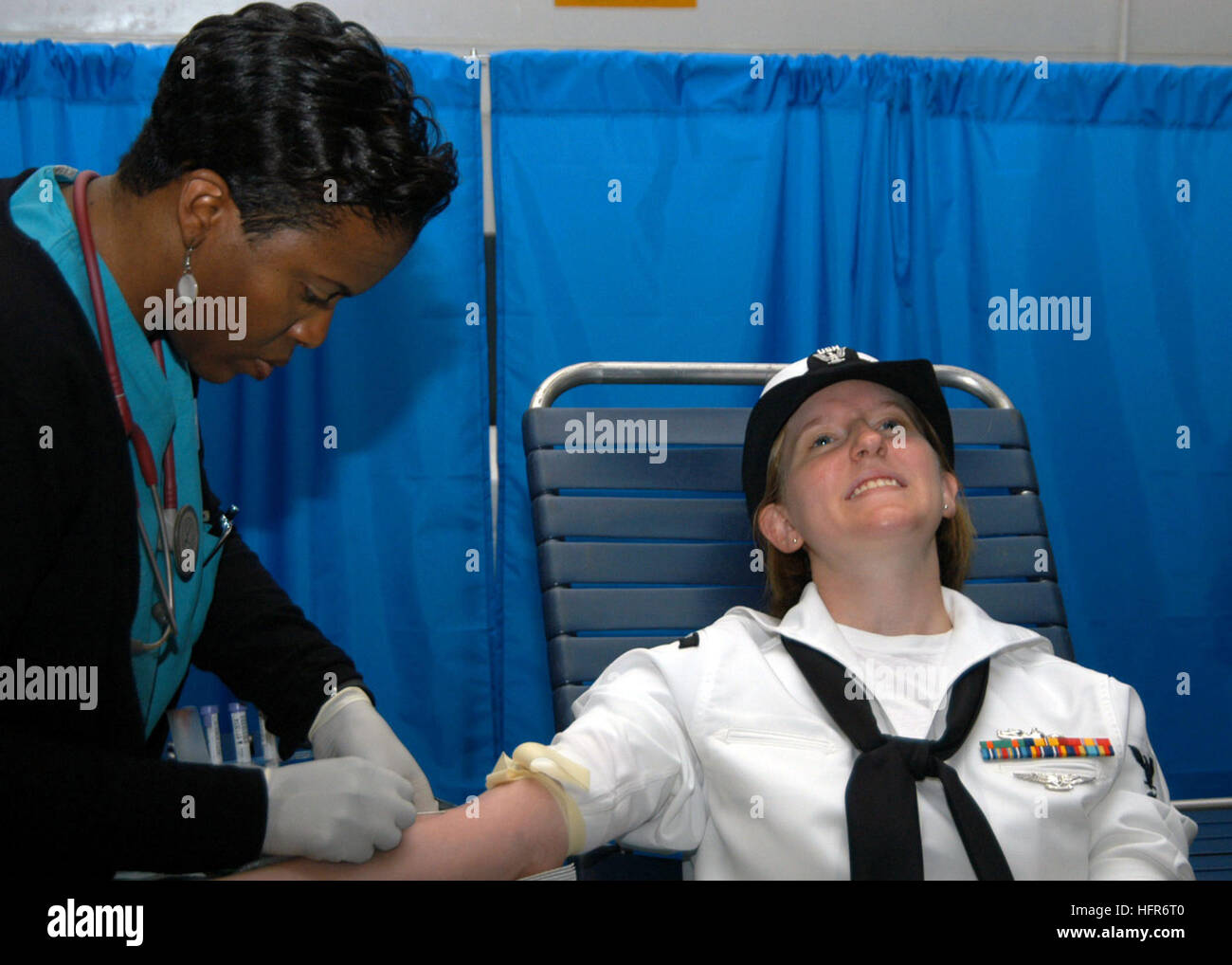 060526-N-7292N-005 New York City (May 26th, 2006) - In the hangar bay aboard the amphibious assault ship USS Kearsarge (LHD 3), a New York City blood center worker, Michelle Simon-Francis carefully retracts a needle from blood donor Personnel Specialist 3rd Class Deanna Hoopes. The blood drive is one of several community-relations projects, which Kearsarge and her crew are participating in during Fleet Week 2006. U.S. Navy photo by Mass Communications Specialist Christen Nicholas (RELEASED) US Navy 060526-N-7292N-005 In the hangar bay aboard the amphibious assault ship USS Kearsarge (LHD 3), a Stock Photo