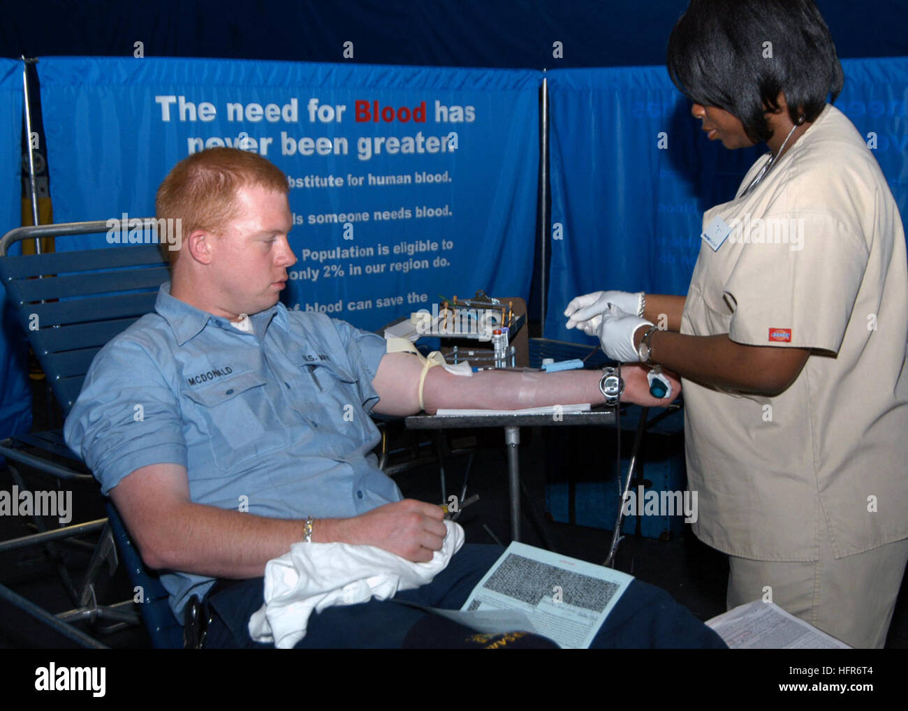 060526-N-7292N-018 New York City (May 26th, 2006) - In the hangar bay aboard the amphibious assault ship USS Kearsarge (LHD 3), a New York City blood center worker, Nitisha Moore takes blood from blood donor Electrician's Mate 3rd Class Jason McDonald. The blood drive is one of several community-relations projects, which Kearsarge and her crew are participating in during Fleet Week 2006. U.S. Navy photo by Mass Communications Specialist Christen Nicholas (RELEASED) US Navy 060526-N-7292N-018 In the hangar bay aboard the amphibious assault ship USS Kearsarge (LHD 3), a New York City blood cente Stock Photo