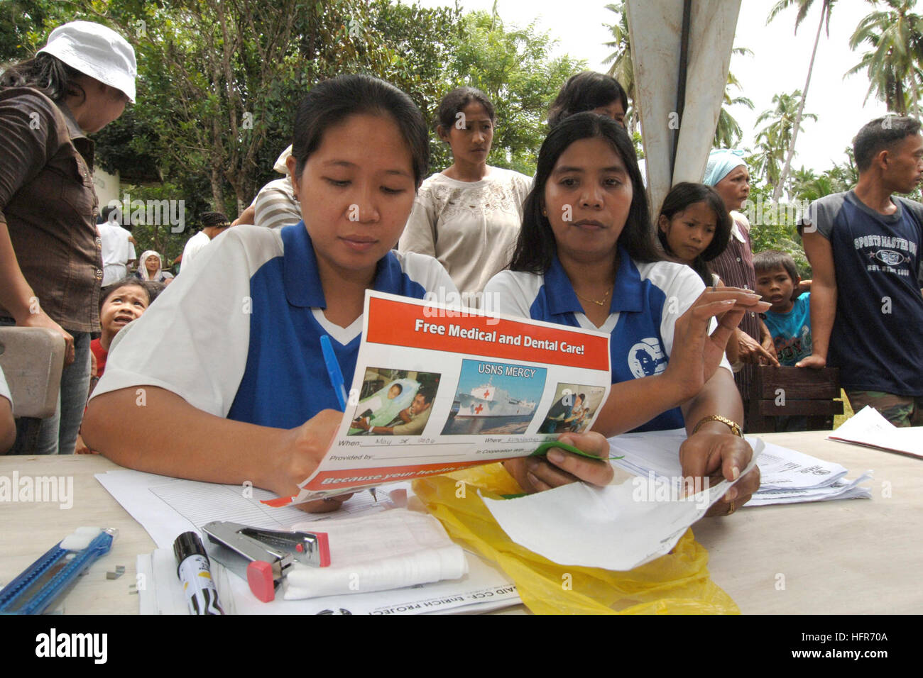 060529-N-6501M-012 Isabella, Republic of the Philippines - (May 29, 2006) - Local Filipino volunteers prepare the necessary paperwork needed to participate in a Medical Civil Action Program (MEDCAP) located on Basilan Island, just south of Zamboanga City.  Medical and dental services are being provided by doctors and staff from the U.S. Military Sealift Command (MSC) hospital ship, USNS Mercy (T-AH 19), together with non-governmental organizations.  MEDCAPs are an integral part of Mercy's humanitarian mission and provide a multitude of medical, dental and veterinary care for the people who liv Stock Photo