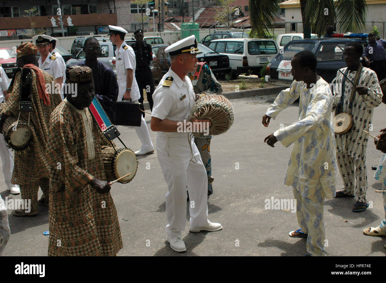 060602-N-8637R-002 Lagos, Nigeria (June 2, 2006) - Commander, Destroyer Squadron Six Zero (COMDESRON-60), Commodore Tom Rowden, dances with a drummer with the Oba of Lagos, Nigeria. The Oba is a spiritual leader in Nigerian culture and regarded as royalty.  Rowden is in Nigeria aboard the guided-missile destroyer USS Barry (DDG 52) representing the U.S. Navy during the Golden Jubilee of Nigeria's Navy, which marks the 50th anniversary of the Nigerian Navy. The port visit and participation in the Golden Jubilee is the latest in a series of engagements involving several Gulf of Guinea nations de Stock Photo