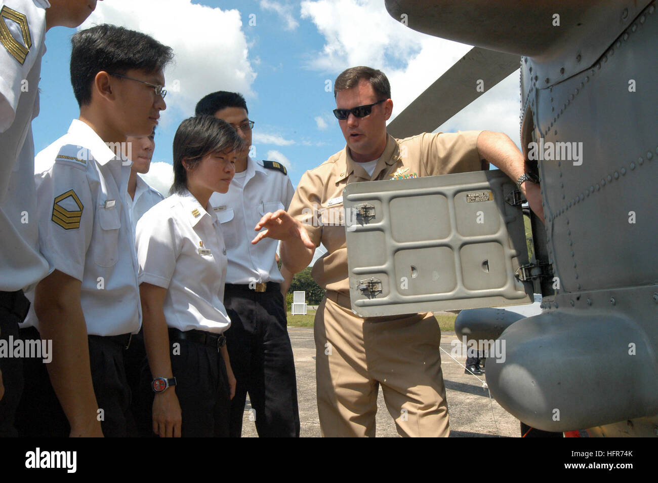 060601-N-4205W-008 Singapore (June 1, 2006) - Officer in Charge Anti-Submarine Squadron Light Three Seven (HSL-37) Detachment 5, Lt. Cmdr. Colin Smith, explains the capabilities of the SH-60B Seahawk helicopter to a group of Republic of Singapore Air Force and Navy personnel during a professional exchange as part of the Singapore phase of exercise Cooperation Afloat Readiness and Training (CARAT). CARAT is an annual series of bilateral maritime training exercises between the United States and six Southeast Asia nations designed to build relationships and enhance the operational readiness of th Stock Photo