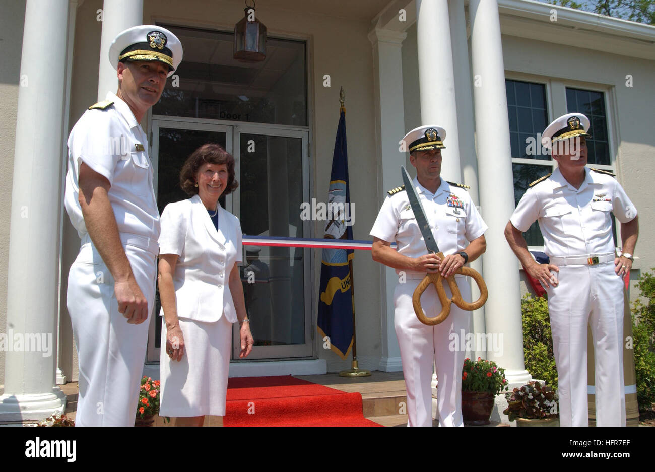 060608-N-3218H-122 Yorktown, Va. (June 8, 2006) - Commanding Officer Naval Weapons Station Yorktown, Capt. Gerard O'Regan, prepares to cut the ribbon for the official opening of the Naval Munitions Command as, Rear Adm. Ray Berube, Dr. Frances Holt, and Adm. John Nathman stand by. The Naval Munitions Command will align all current ashore ordnance support operations in the United States and Asia into one worldwide unit to consolidate resource requirements, standardize policies and streamline procedures for a more responsive, flexible and efficient fleet ordnance support structure. U.S. Navy pho Stock Photo