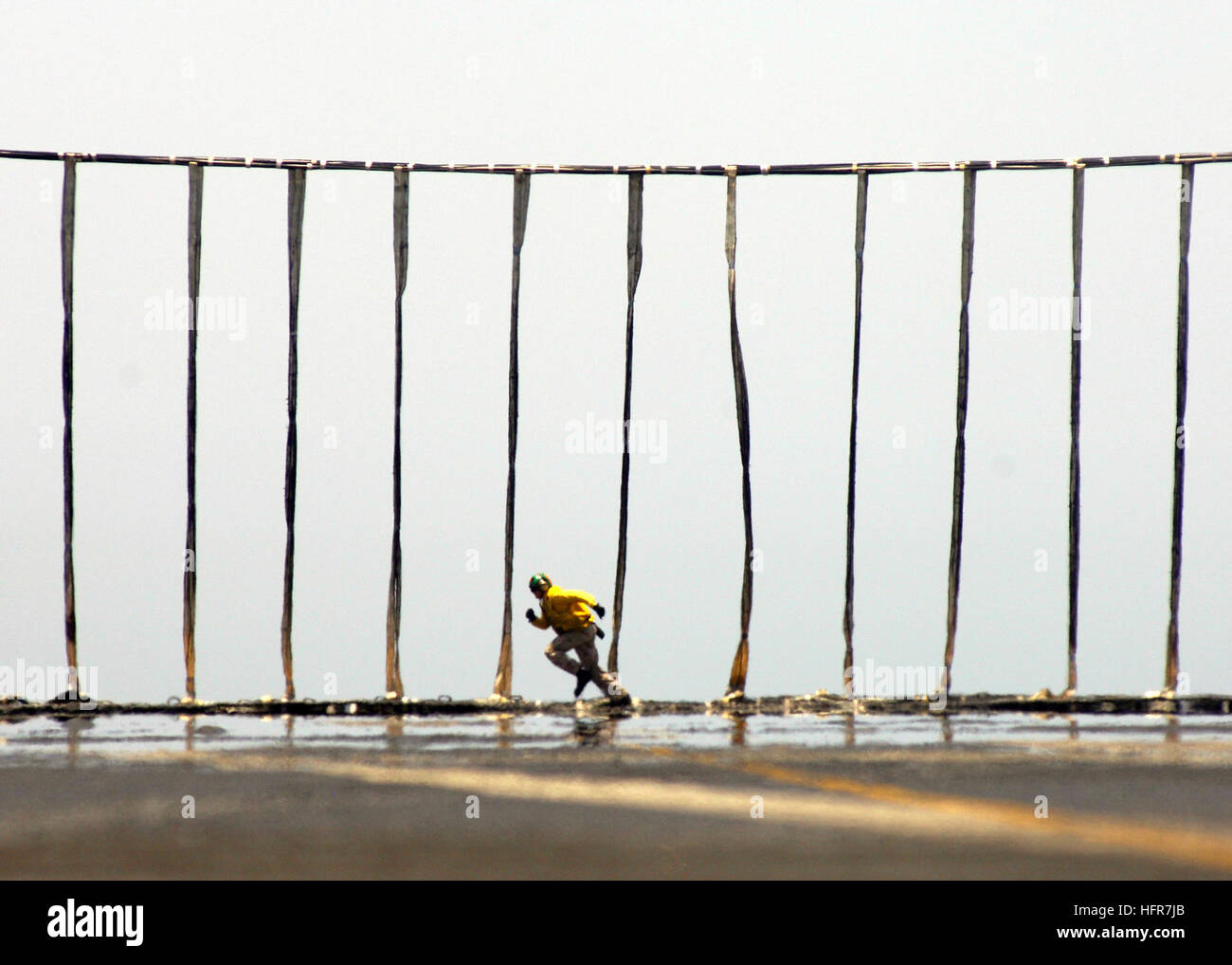 060611-N-9742R-075  Persian Gulf (June 11, 2006) - A flight deck officer runs along the length of an erected aircraft barricade checking its integrity during a barricade drill on the flight deck of the nuclear-powered aircraft carrier USS Enterprise (CVN 65). The Enterprise Carrier Strike group is currently deployed as part of a routine rotation of U.S. maritime forces in support of the global war on terrorism, as well as conducting Maritime Security Operations (MSO) in the region. U.S. Navy photo by Photographer's Mate 2nd Class Milosz Reterski (RELEASED) US Navy 060611-N-9742R-075 A flight d Stock Photo