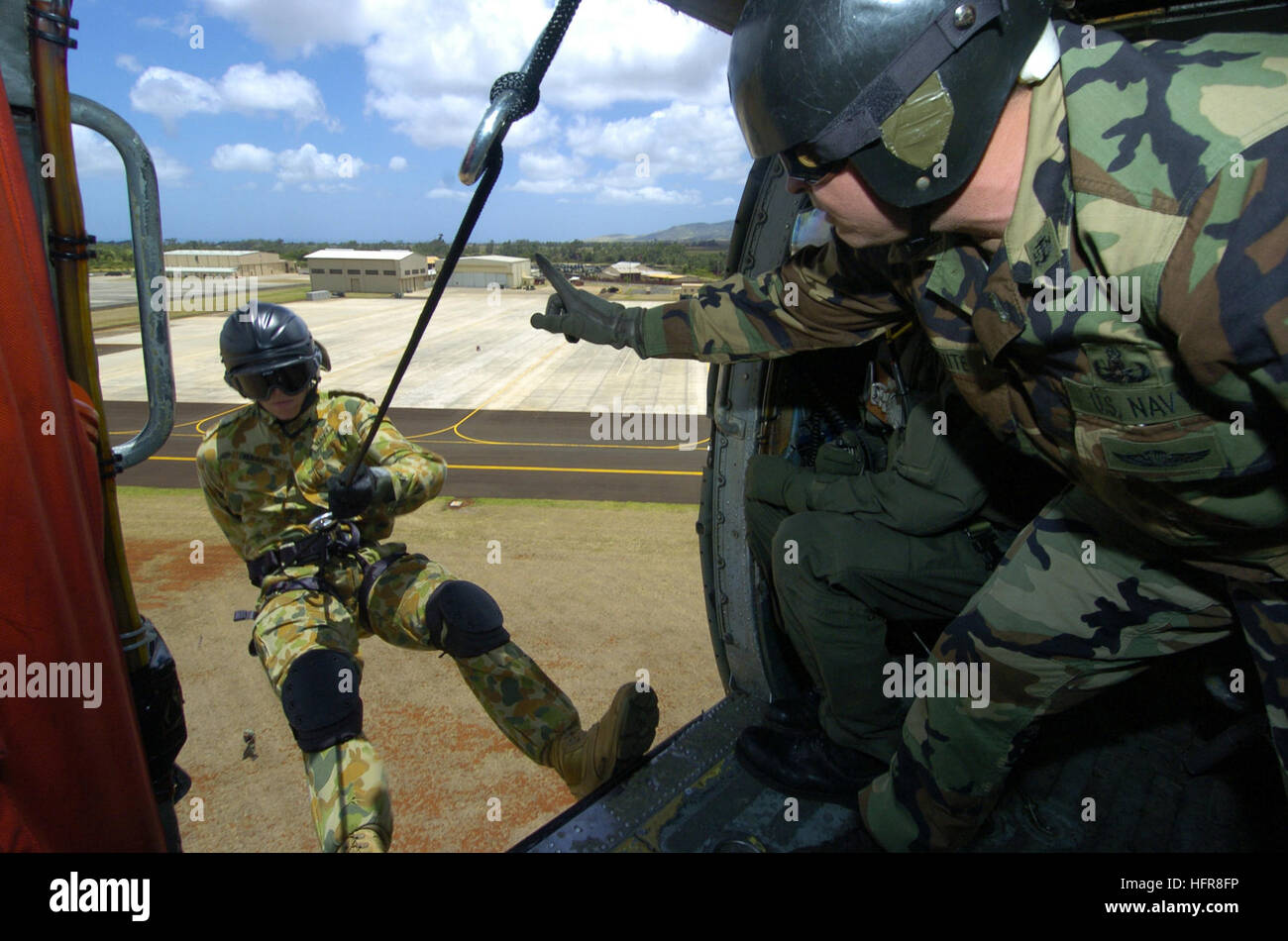 U.S. Navy Chief Lyle White, right, signals to Able Seaman Adam Hubbard of Australia's Clearance Diving Team One as Hubbard prepares to repel from a HH-60H Seahawk helicopter during helicopter rope suspension techniques training as part of exercise Rim of the Pacific (RIMPAC) at Wheeler Army Airfield, Hawaii, July 8, 2006. RIMPAC brings together military forces from Australia, Canada, Chile, Peru, Japan, the Republic of Korea, the United Kingdom and the United States in the world's largest biennial maritime exercise. White is a master explosive ordnance disposalman from Explosive Ordnance Dispo Stock Photo