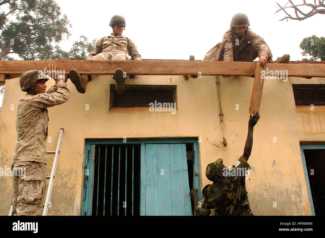 060810-N-9500T-139 Serere, Uganda (Aug. 10, 2006) - Marines assigned to Bridge Co. 'A', 6th Engineering Battalion and soldiers of the Ugandan Peoples' Defense Force work together to build a new roof for the Nurses' Cottage during a Medical Civil Action Program (MEDCAP) as part of Exercise Natural Fire. Natural Fire is the largest combined exercise between Eastern African community nations and the United States. It will include medical, veterinary and engineering civic affairs programs in addition to military exercises. U.S. photo by Mass Communication Specialist 2nd Class Scott Taylor (RELEASE Stock Photo