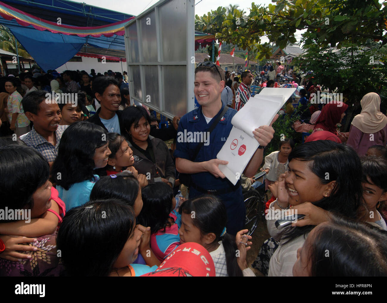 060813-N-8391L-060 Tarakan, Indonesia (Aug. 13, 2006) - U.S. Navy Hospital Corpsman 2nd Class Christopher Orr helps bridge the communications gap by giving local residents a brief lesson on the English language at a local school. This is part of a community relations project with the Military Sealift Command (MSC) hospital ship USNS Mercy (T-AH 19). Mercy is in the fourth month of her five-month humanitarian and civic assistance deployment to South and Southeast Asia where her crew has already treated thousands of people. U.S. Navy photo by Mass Communication Specialist 1st Class Troy Latham ( Stock Photo