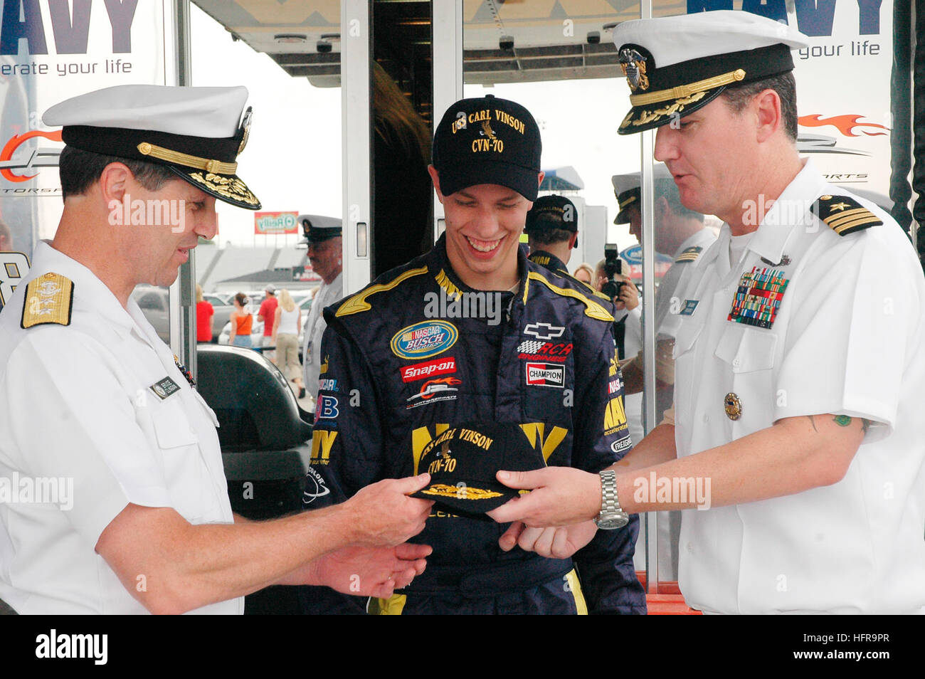 070728-N-5362H-052 INDIANAPOLIS (July 28, 2007) Ð Rear Adm. Bruce Clingan receives a command ball cap from Cmdr. John Harber, intel officer aboard USS Carl Vinson (CVN 70) during a meet and greet with Navy NASCAR team driver Brad Keselowski before the Kroger 200 Bush series race at the O'Reilly Raceway Park in Indianapolis. Clingan and seven Sailors from Carl Vinson attended the race as the Fleet Honorary, to cheer on the number 88 Navy Chevy Monte Carlo. U.S. Navy photo by Mass Communication Specialist Seaman Nina Hughes (RELEASED) US Navy 070728-N-5362H-052 Rear Adm. Bruce Clingan receives a Stock Photo