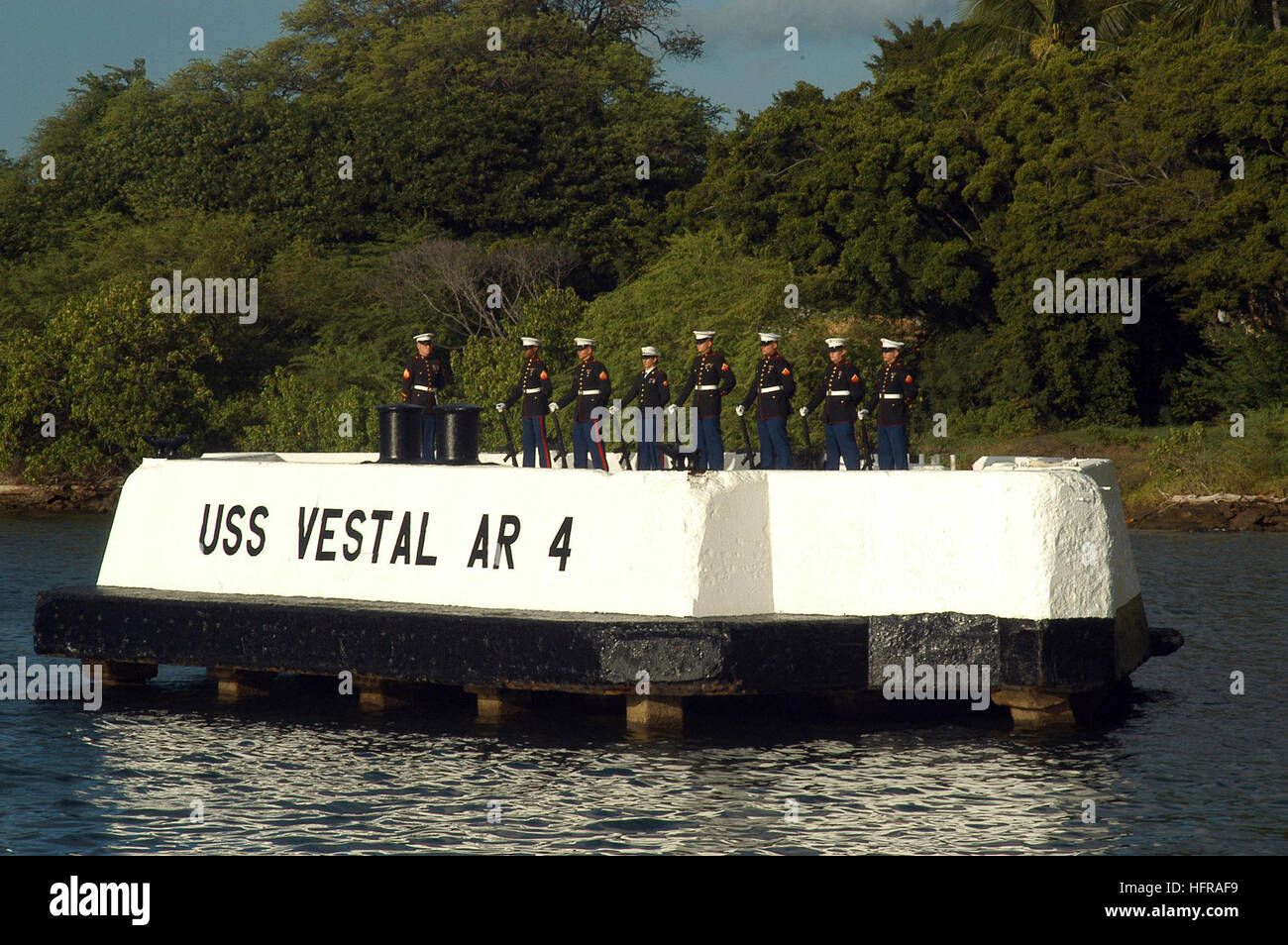 041207-N-6775N-102 Pearl Harbor, Hawaii (Dec. 7, 2004) - U.S. Marines, assigned to Marine Aircraft Group Two Four (MAG-24), stand at parade rest prior to a twenty-one gun salute on the USS Vestal mooring quay. Vestal, a repair ship, was moored outboard of the battleship USS Arizona during the attack on Pearl Harbor. She was hit by two bombs and further damaged when Arizona's forward magazines exploded. Repaired over the next few months, she was transferred to the South Pacific in August 1942, where she mended many combat-damaged ships during difficult times of the Guadalcanal and Central Solom Stock Photo