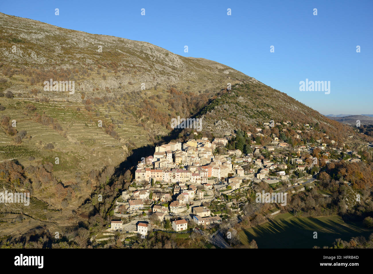AERIAL VIEW. Perched medieval village on a limestone ridge. Coursegoules, Alpes-Maritimes, French Riviera's backcountry, France. Stock Photo