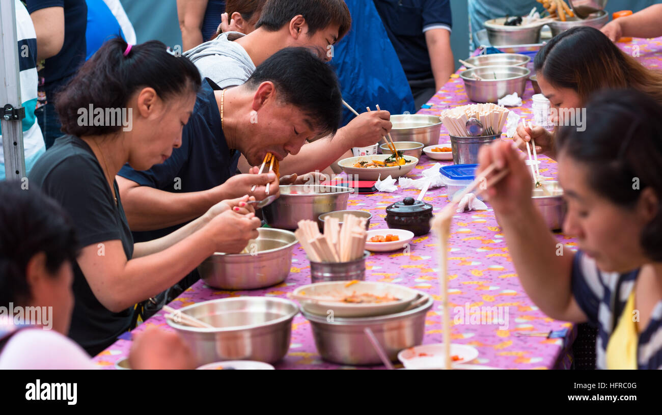 Local Korean people eating with chopsticks in Busan, South Korea. Stock Photo