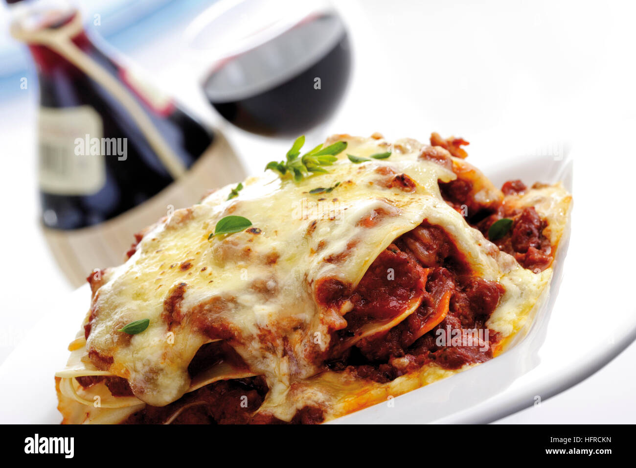 Lasagna, red wine in background Stock Photo