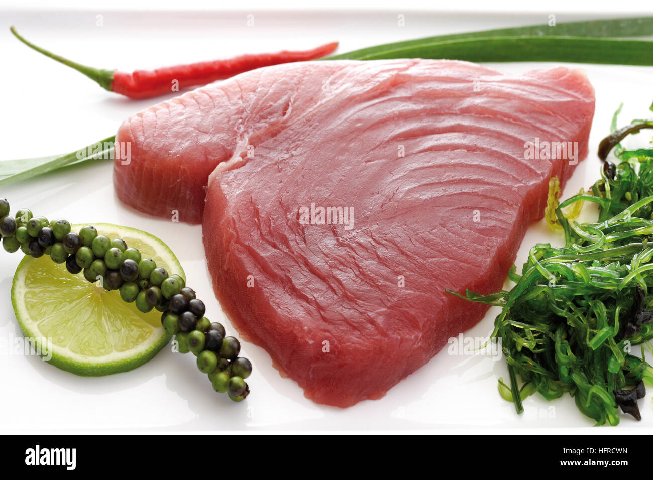 Raw tuna with algae, lime slice, green pepper and leek Stock Photo Alamy