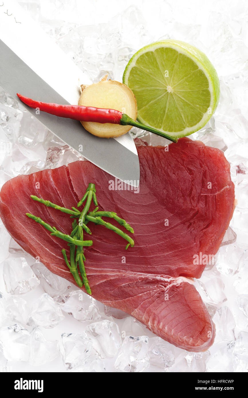 Raw tuna with algae, lime slice, chili pepper and ginger on crushed ice
