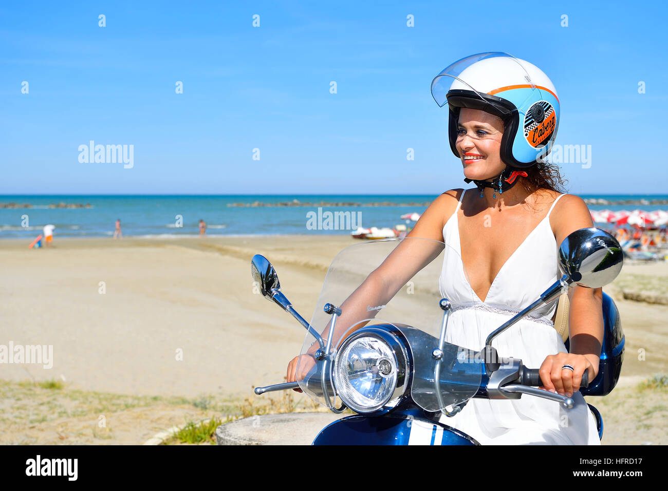 Woman on Vespa scooter, beach, Senigallia, Province of Ancona, Marche, Italy Stock Photo