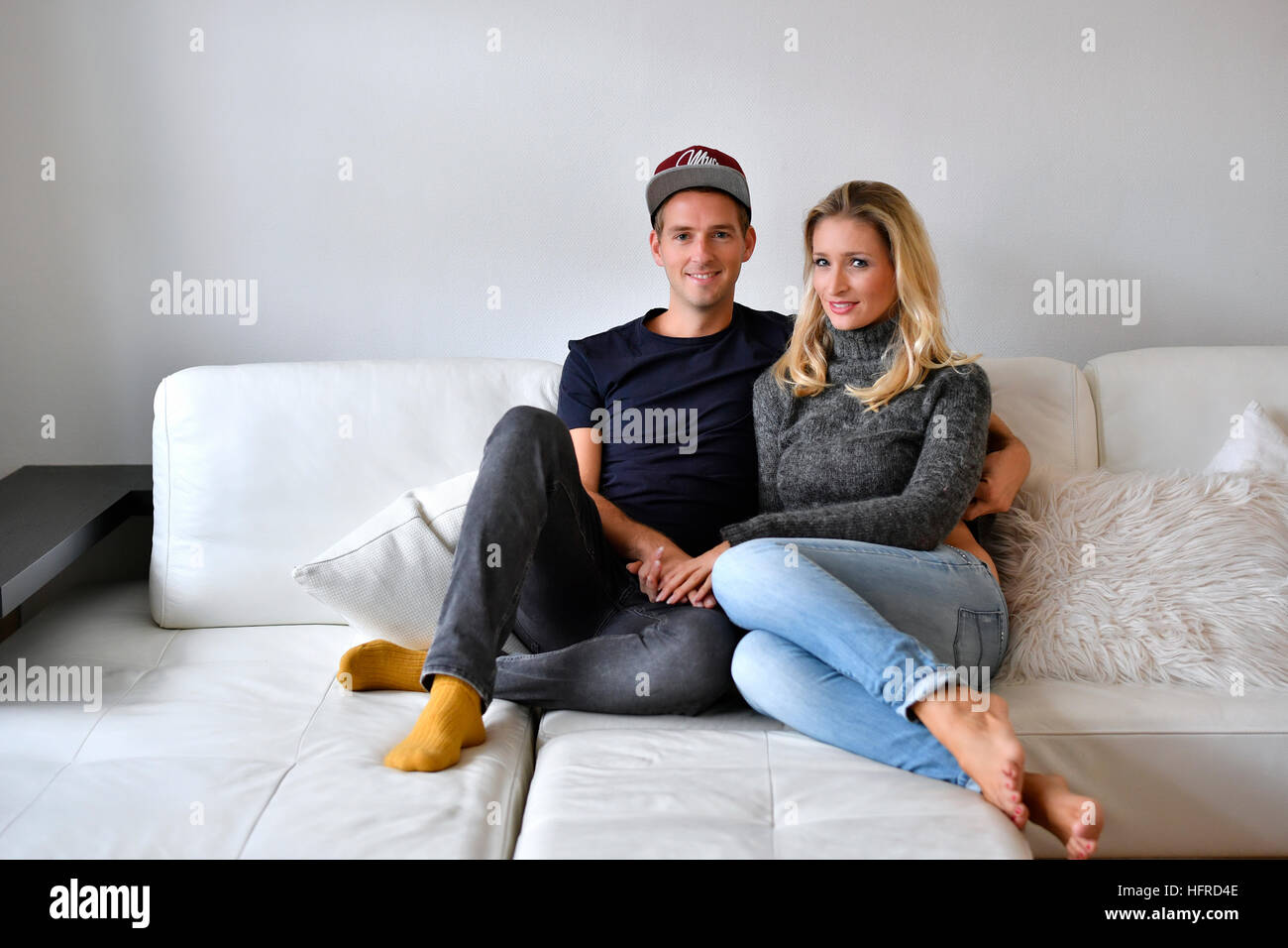 Young couple, lovers sitting on sofa Stock Photo - Alamy