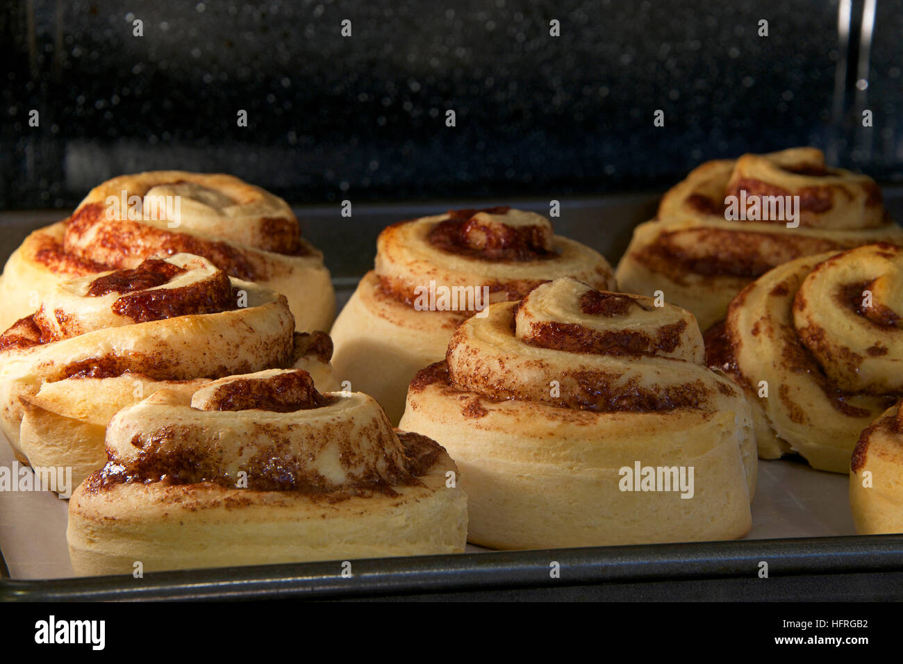 Hot Cinnamon rolls baking in a convection oven, almost done tops coming