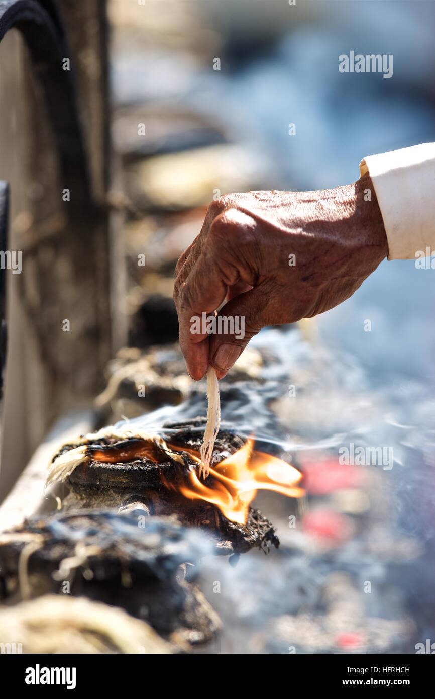 Kathmandu Bhaktapur temple worship oil lamps string fire smoke hand