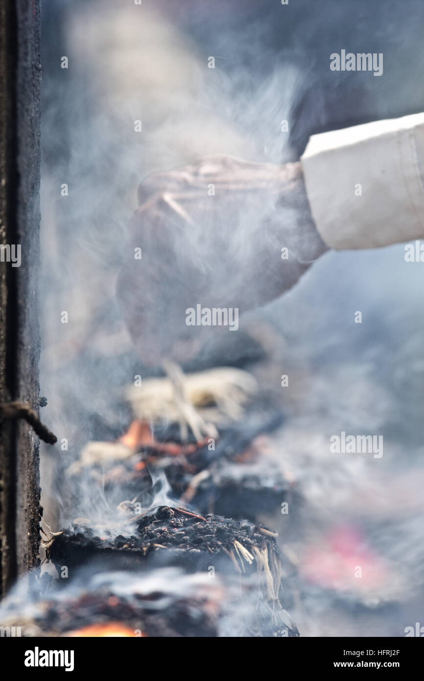 Kathmandu Bhaktapur temple worship oil lamps string fire smoke hand