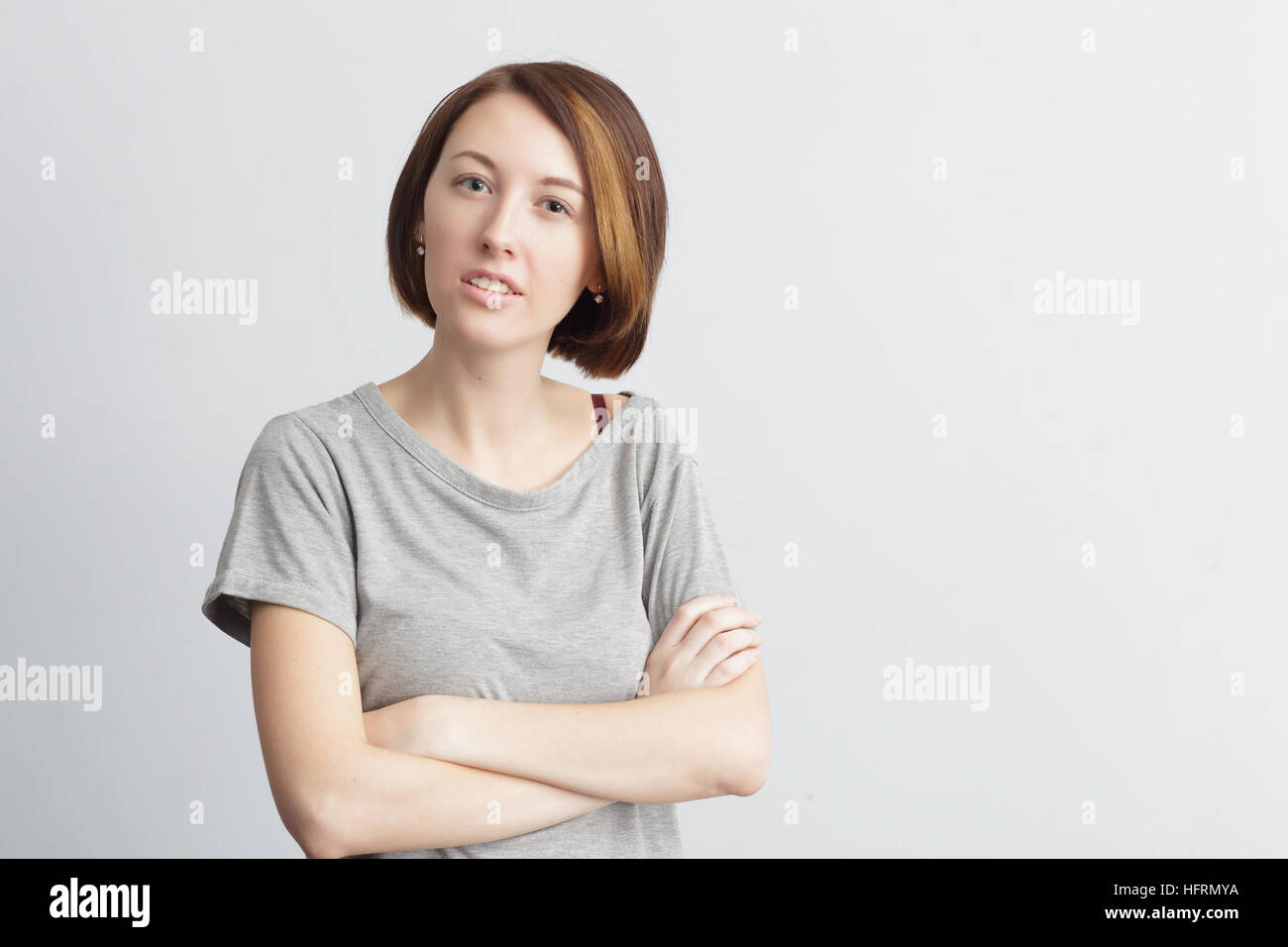 Girl with incomprehension and indignation looks forward. Understand the strange situation Stock Photo