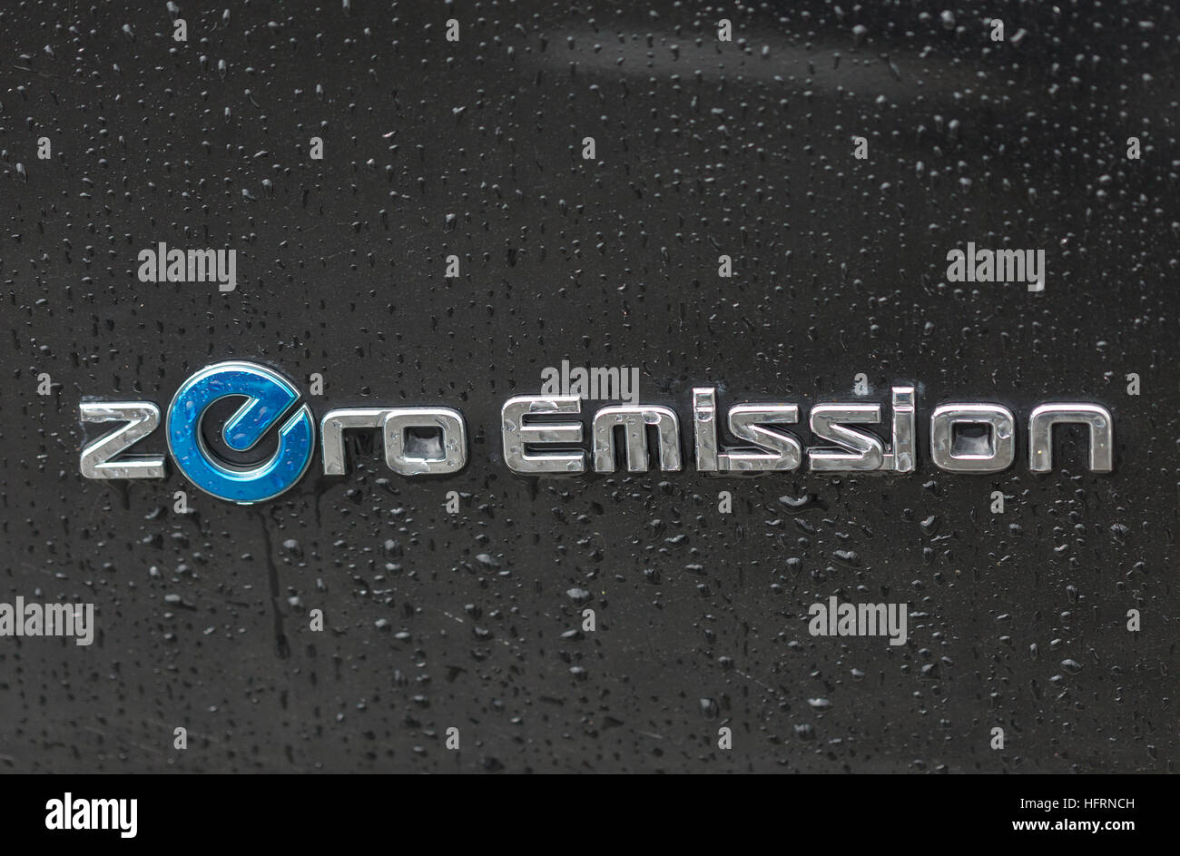 Nissan Zero Emission electric hybrid car logo closeup outdoor under the rain. Stock Photo