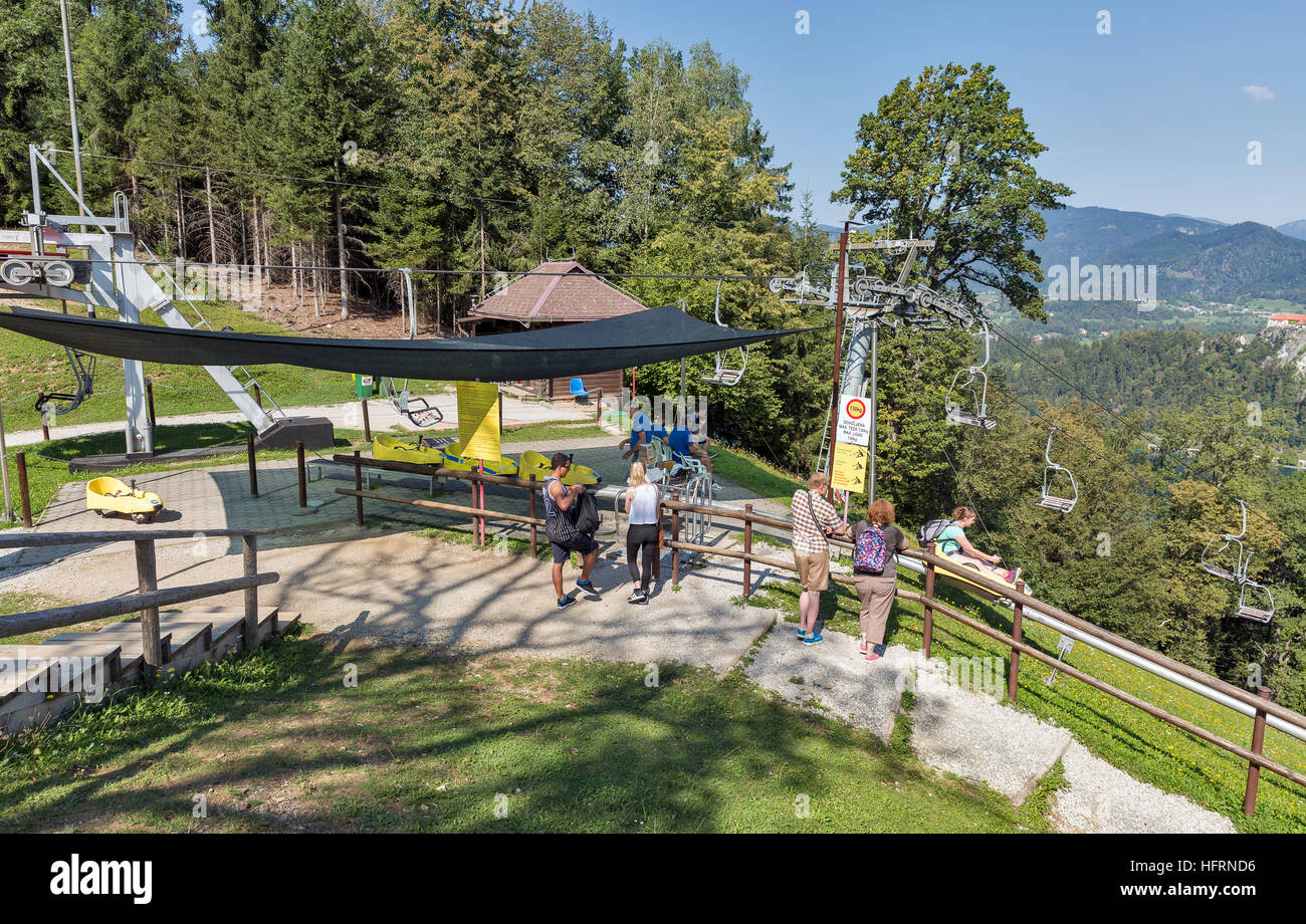 Unrecognized people visit summer toboggan and chair lift upper station