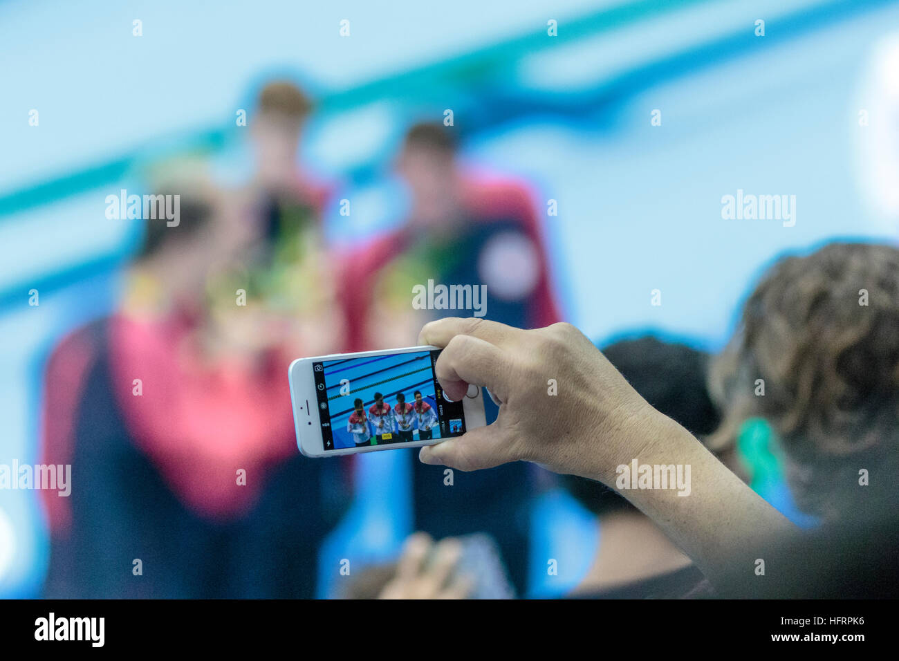 Rio de Janeiro, Brazil. 9 August 2016.   Spectator using mobile phone to photograph Team Japan the silver medal winners of the Men's 4x200m freestyle Stock Photo