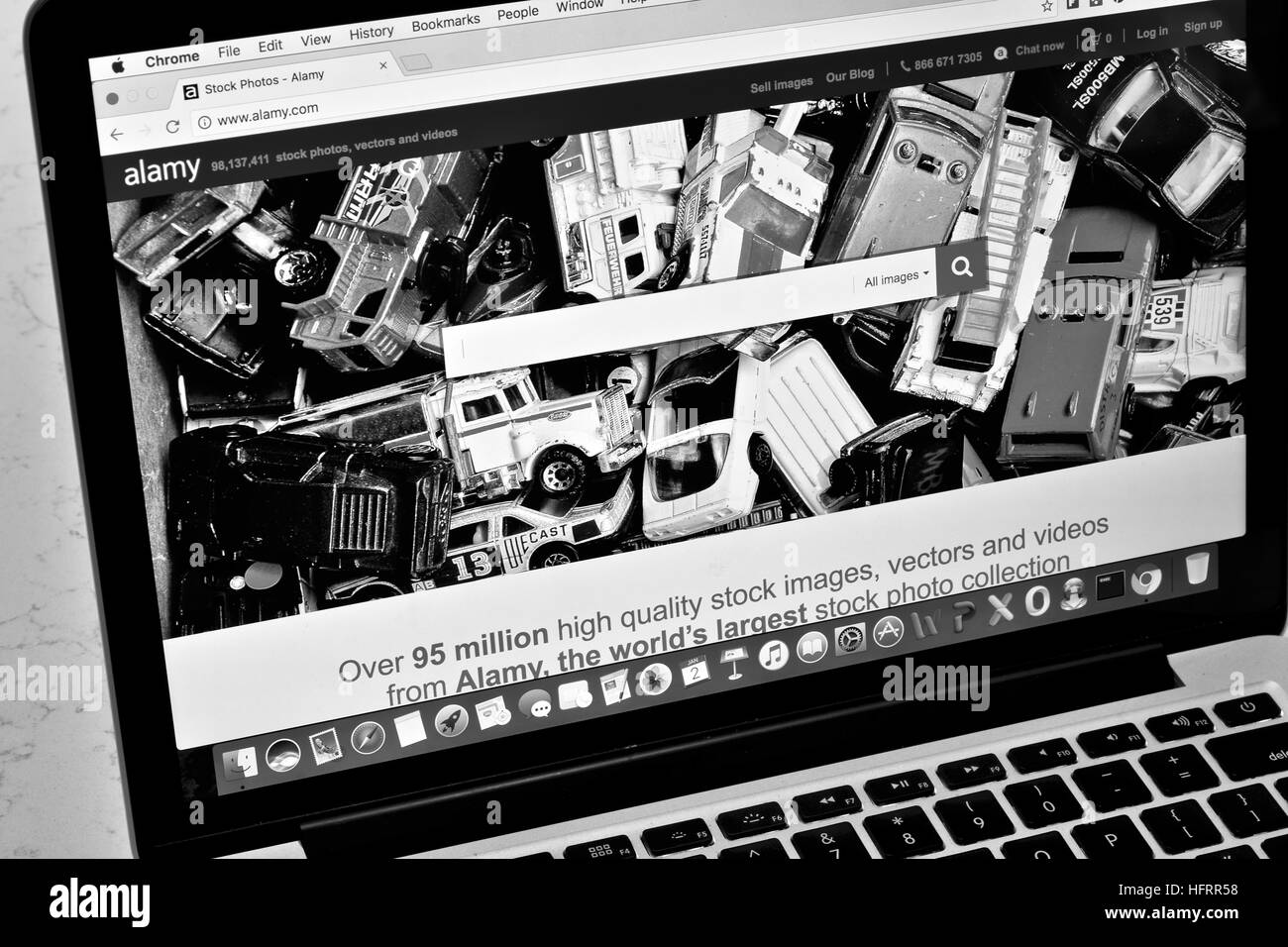 An Apple Macbook Pro displaying the Alamy stock photo website in black and white Stock Photo