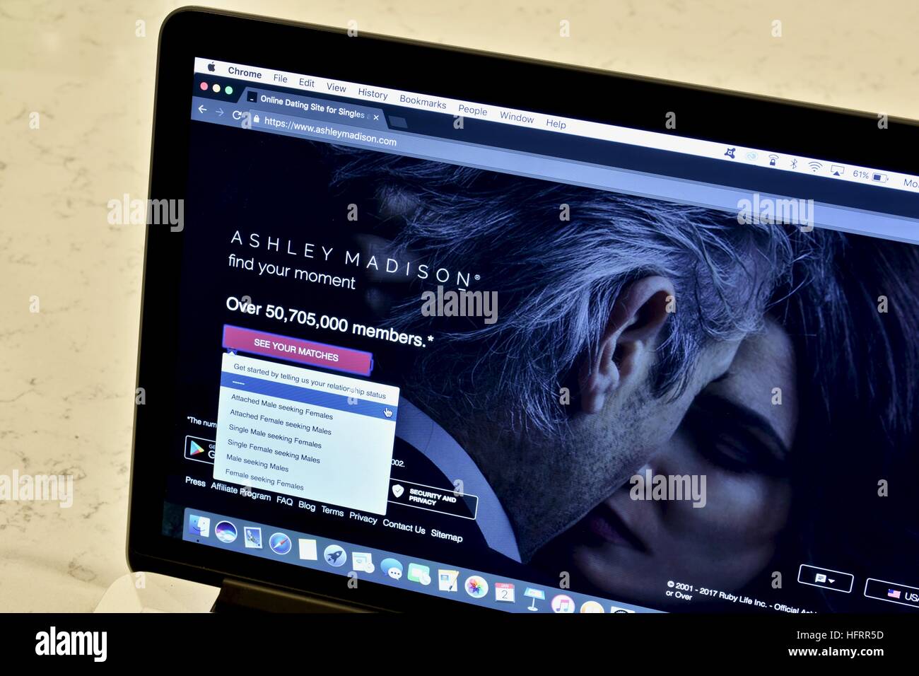 An Apple Macbook Pro displayed on a white marble surface with a married man viewing the Ashley Madison hookup website Stock Photo