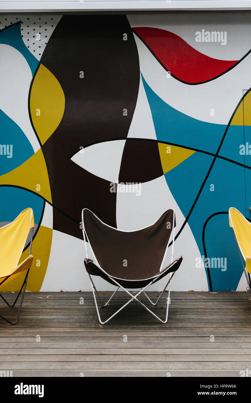 Chairs and the mural painting on the outdoor deck of Rose Seidler House, part of the Sydney Living Museums, design by architect Harry Seidler. Stock Photo