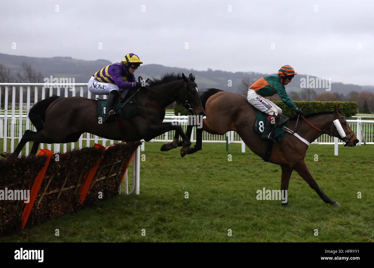 Agrapart ridden by Lizzie Kelly trails Cole Harden ridden by Gavin Sheehan over an early flight before going on to win The Dornan Engineering Relkeel Handicap Hurdle Race run at Cheltenham Racecourse. Stock Photo