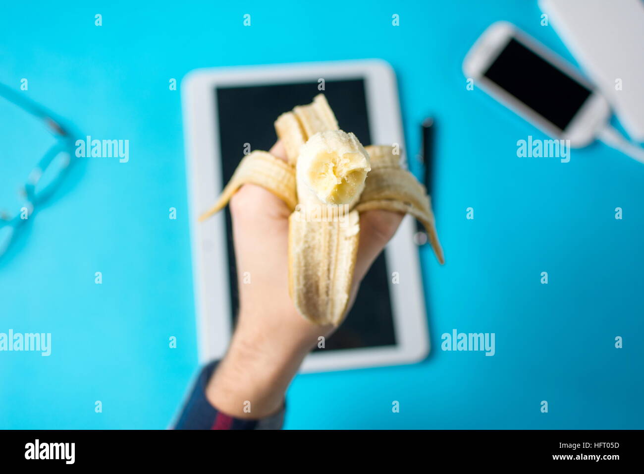 Man holding a banana at work in the office Stock Photo
