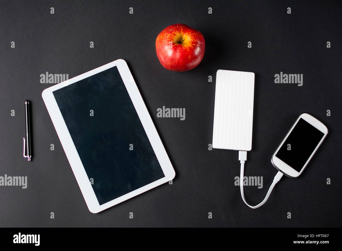 Red apple and white electronic devices. Snack at work Stock Photo
