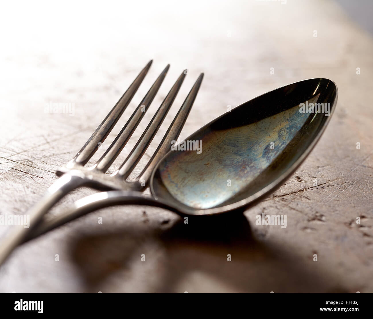 Antique fork and spoon photographed close up with shallow focus. Sepia toned fine art wall decor Stock Photo