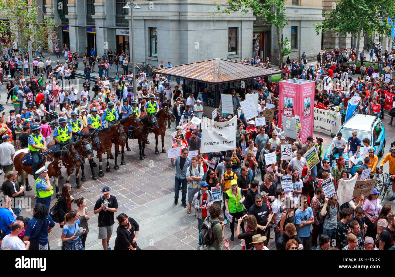 Protesters march past mounted police Stock Photo