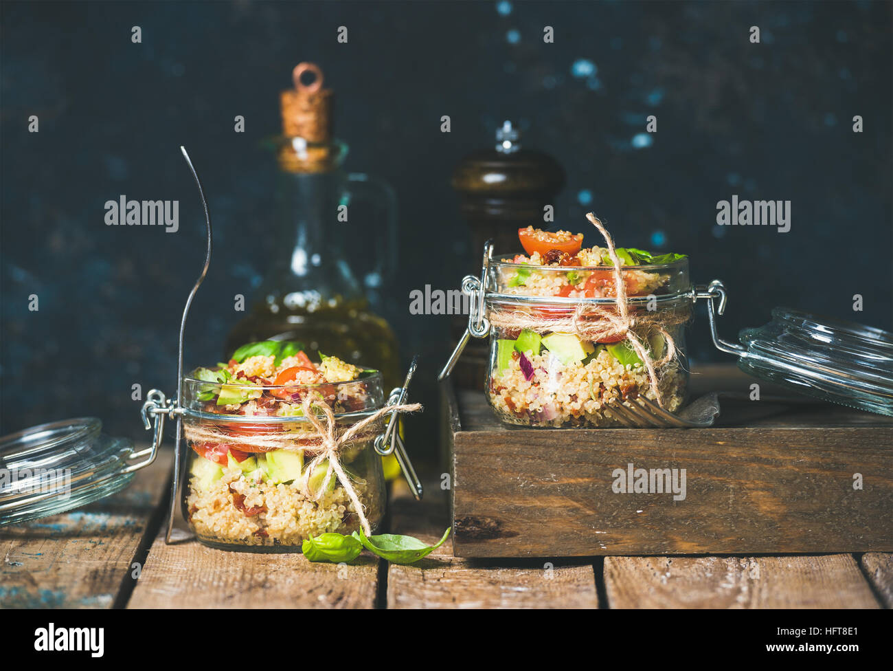 Homemade jar quinoa salad with cherry and sun-dried tomatoes, avocado and fresh basil. Detox, dieting, vegetarian, vegan, clean eating food concept. D Stock Photo