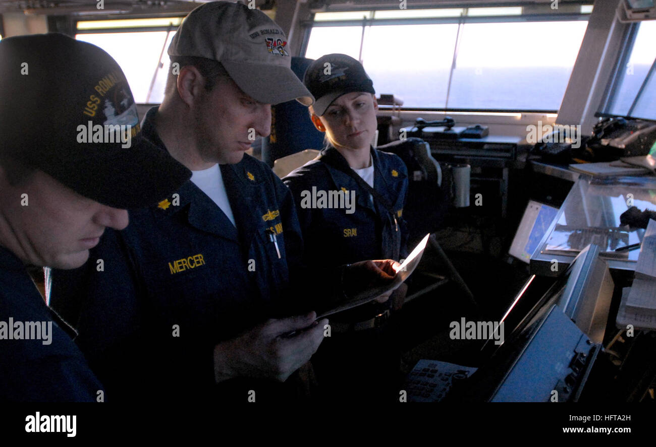 Bridge officers discuss ship navigation and conning procedures aboard ...