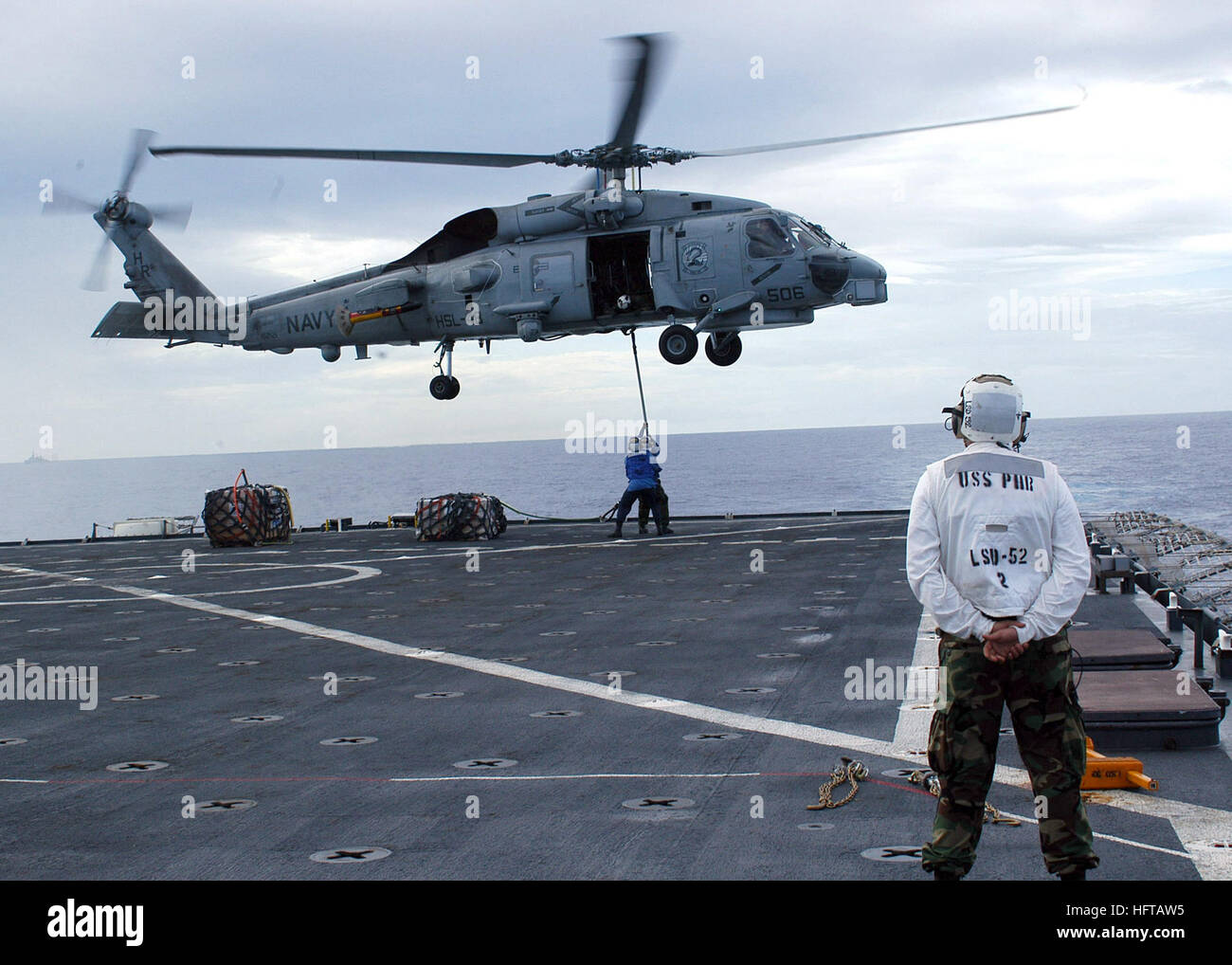 070416-N-4021H-130  ATLANTIC OCEAN (April 16, 2007) - An SH-60B Seahawk, assigned to Anti-Submarine Squadron (HSL) 48, picks up pallets on the flight deck of dock landing ship USS Pearl Harbor (LSD 52) during a vertical replenishment to deliver food, medical supplies and toys to guided missile destroyer USS Mitscher (DDG 57) for distribution in Montevideo, Uruguay, during Partnership of the Americas (POA) 2007. POA will focus on enhancing relationships with partner nations through a variety of exercises and events at sea and on shore throughout South America and the Caribbean. U.S. Navy Photo  Stock Photo