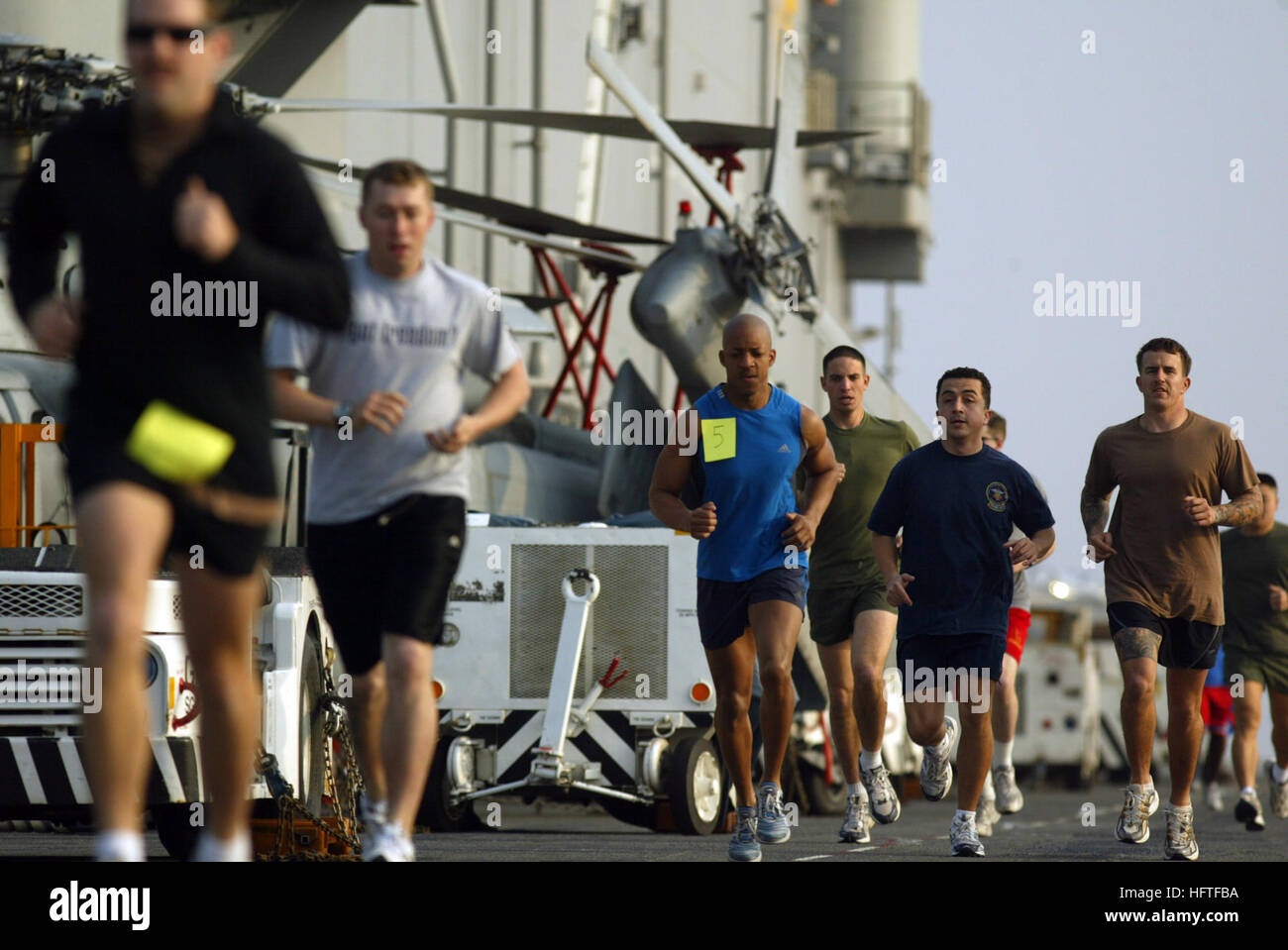 USS ESSEX (LHD 2), At Sea -- Master Sgt. Dervin Deryck (left) Lt. Javier Agrac (middle) and Explosive Ordnance Disposal 1st Class  Nick Matics (right) stride side-by-side during a five-kilometer fun run held by Moral, Welfare and Recreation Feb. 10, 2007. Essex is the Navy's only forward deployed multi-purpose amphibious assault ship and is the flagship for the Essex Amphibious Readiness Group (ARG) operating from Sasebo, Japan. (Official U.S. Navy photo by Mass Communication Specialist 3rd Class Jhoan M. Montolio) US Navy 070211-N-4207M-004 Sailors station aboard the amphibious assault ship U Stock Photo