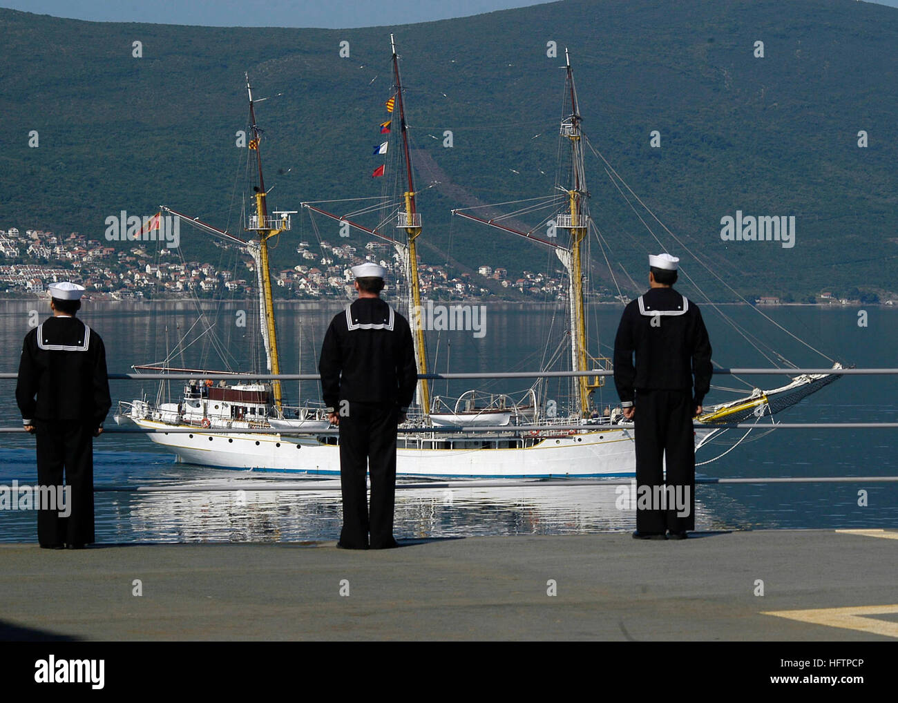 070525-N-2566U-002 TIVAT, Montenegro (May 25, 2007) Ð Sailors on board USS Emory S. Land (AS 39) man the rails as Montenegrin training vessel Jadran sails in the background. Emory S. Land is the third U.S. Navy ship to visit Montenegro since the United States began diplomatic relations with the country in August 2006. U.S. Navy photo by Mass Communication Specialist 2nd Class Jesus Uranga (RELEASED) US Navy 070525-N-2566U-002 Sailors on board USS Emory S. Land (AS 39) man the rails as Montenegrin training vessel Jadran sails in the background Stock Photo