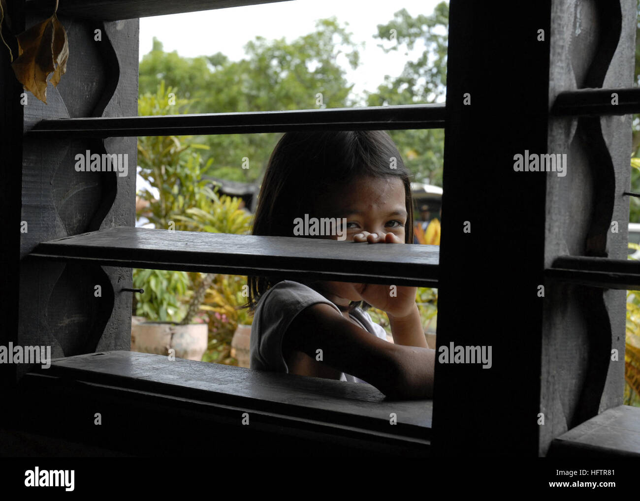 070616-N-4267W-024 COTABATO, Philippines (June 16, 2007) - A Filipino child looks through the window of a school that will be remodeled with the cooperation from members of the Filipino 54th Engineering Brigade, Naval Mobile Construction Battalion (NMCB) 7, and Amphibious Construction Battalion (ACB) 1. NMCB-7 and ACB-1 are deployed with amphibious assault ship USS Peleliu (LHA 5) in support of Pacific Partnership 2007, a four-month humanitarian assistance mission to Southeast Asia and Oceania that includes specialized medical care and various construction and engineering projects. U.S. Navy p Stock Photo